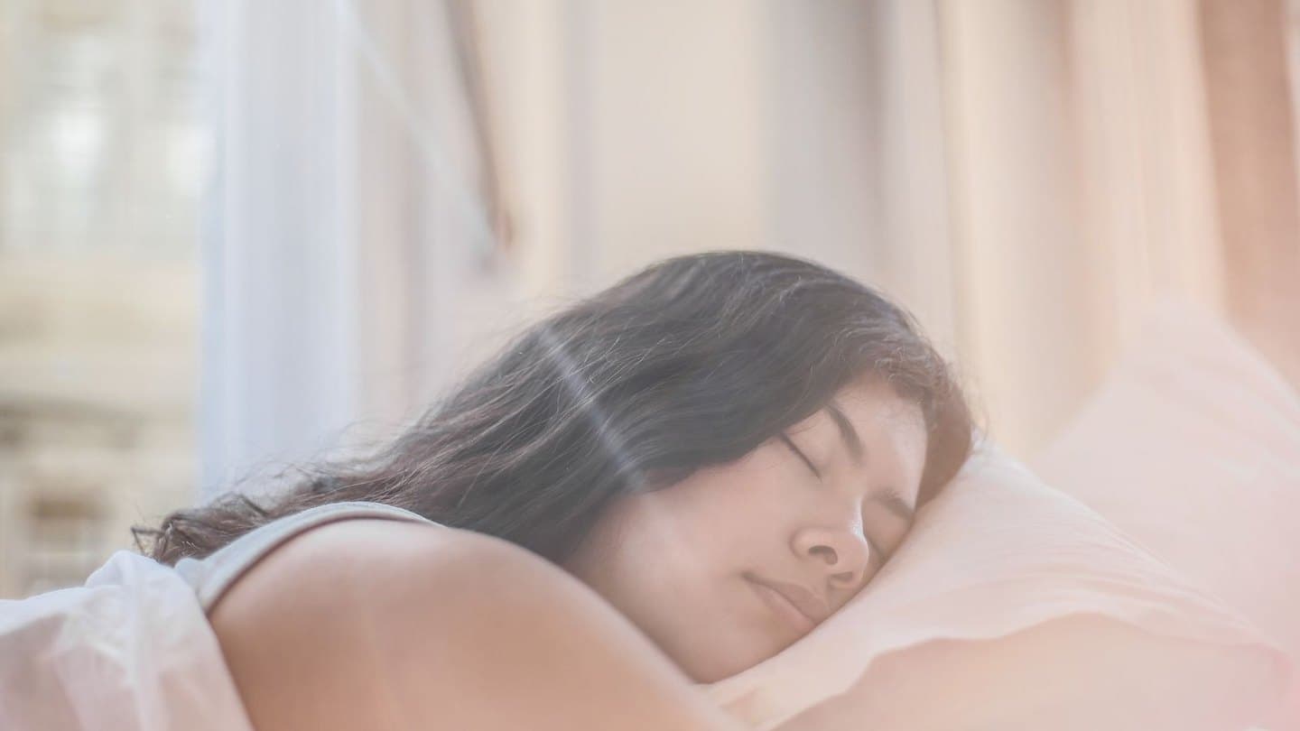 Femme endormie dans la lumière douce du matin