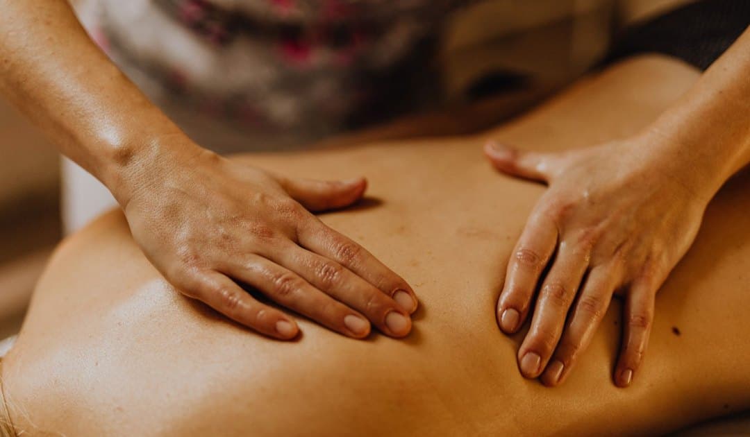 Mains du praticien travaillant le dos lors d’un massage Tuina